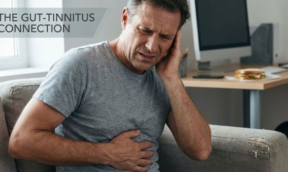 Man in his 40s holding his ear due to tinnitus and his stomach. Words saying "the Gut tinnitus connection"
